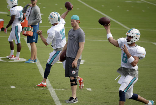 Miami Dolphins quarterback Ryan Tannehill, center, watches as quarterbacks T.J. Yates (16) and Matt Moore (8) throw during NFL football practice, Wednesday, Jan. 4, 2017 in Davie, Fla. Tannehill didn't take part in practice, making it unlikely he'll return from a left knee injury. The Dolphins play the Pittsburgh Steelers in an AFC Wild-Card game Sunday. (AP Photo/Lynne Sladky)